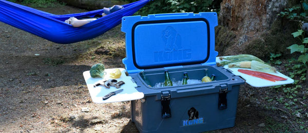 KONG 50 quart cooler open with cutting two cutting boards. Cooler filled with ice and beverages