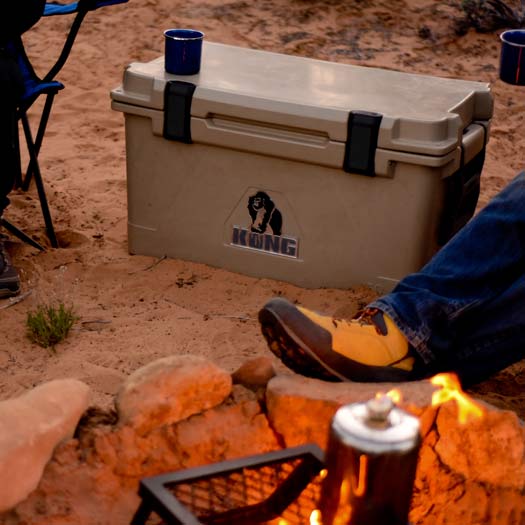 Closed KONG Cooler 70 quart rotomolded cooler between two chairs around a camp fire