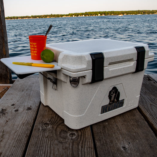 25 Quart KONG Cooler white in color on fishing dock with cutting board attached